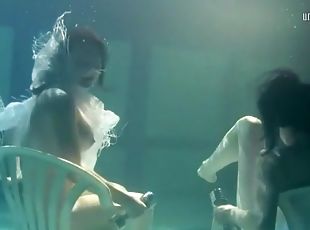 Pretty girls hold weights to stay underwater