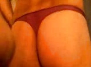 A slim chick wearing thong shows her nice butt for the cam