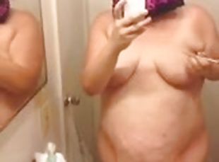 Chubby amateur brunette writes on her big tits in front of a mirror