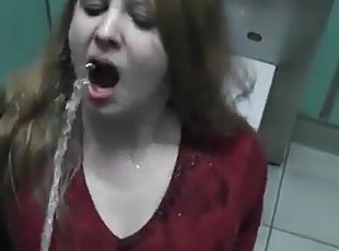 Rothaarige Freundin trinkt Urin in einer öffentlichen Toilette