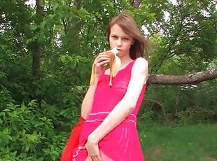Teen outdoors in pantyhose eats a banana