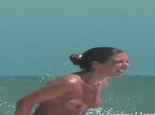 Sexy toned body walking naked on a crowded nudist beach