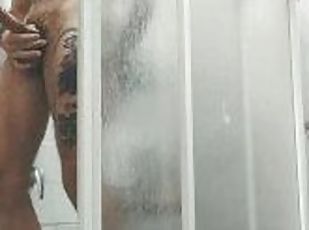 Chico tatuado masturbándose en la ducha